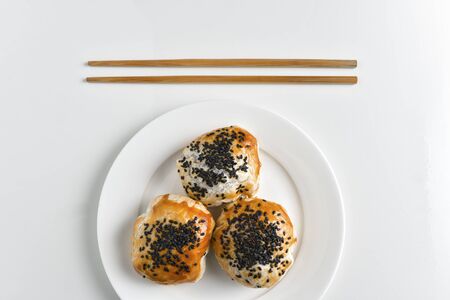 Chinese red bean paste cakes and chopsticks on ceramic plate, isolated on white backgroundの写真素材