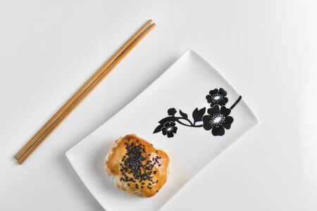 Chinese red bean paste cakes and chopsticks on ceramic plate, isolated on white backgroundの写真素材