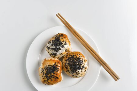 Chinese red bean paste cakes and chopsticks on ceramic plate, isolated on white backgroundの写真素材