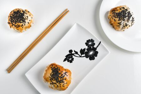 Chinese red bean paste cakes and chopsticks on ceramic plate, isolated on white backgroundの写真素材
