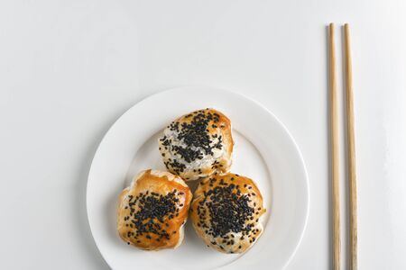 Chinese red bean paste cakes and chopsticks on ceramic plate, isolated on white backgroundの写真素材