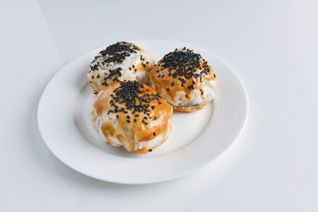 Chinese red bean paste cakes on ceramic plate, isolated on white backgroundの写真素材