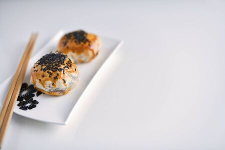 Chinese red bean paste cakes and chopsticks on ceramic plate, isolated on white backgroundの写真素材
