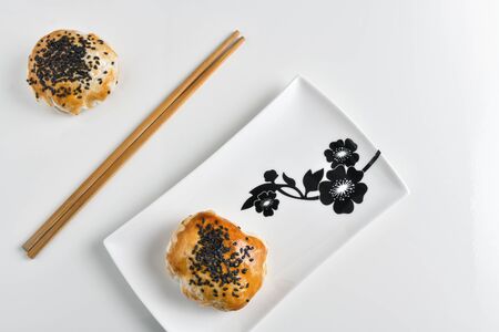 Chinese red bean paste cakes and chopsticks on ceramic plate, isolated on white backgroundの写真素材
