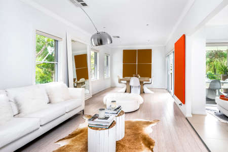 Interior shot of a modern living room with sofas in the foreground, table and paintings in the backgroundの写真素材