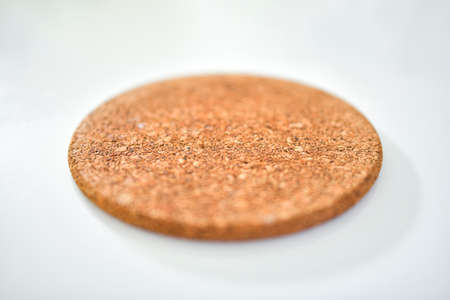 Close up of a cork placemat on white table with blurred backgroundの写真素材