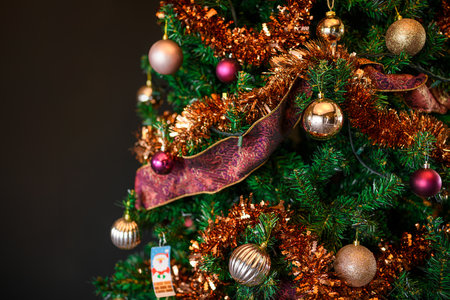 Decorated beautiful Christmas tree on blurred dark backgroundの写真素材