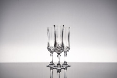 Cut glass crystal stemware champagne flute, isolated on shiny gray surface with gray background.の写真素材