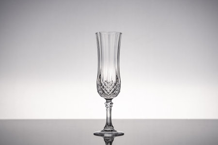 Cut glass crystal stemware champagne flute, isolated on shiny gray surface with gray background.の写真素材
