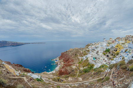 Beautiful panoramic view of Oia village on Santorini island in Greece in summer with dramatic skyの写真素材