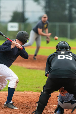 Men playing baseball game. Batter getting ready to hit a pitch during ballgame on a baseball diamond, field.の写真素材