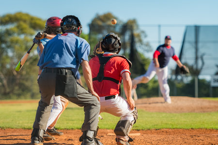 Men playing baseball game. Batter getting ready to hit a pitch during ballgame on a baseball diamond, field.の写真素材