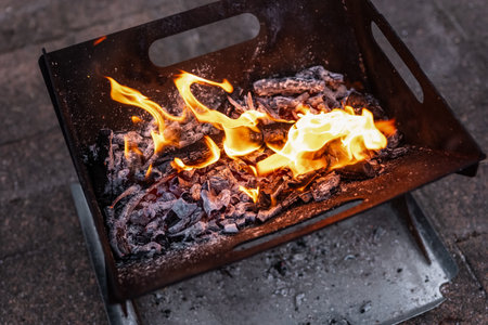 Close up of campfire, fire pit filled with burnt wood and flames. Fire burning, embers glowing.の写真素材