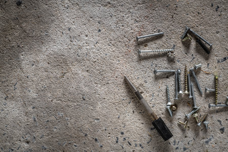Screw, nail on concrete texture background. Closeup of screws and nails on cement floor with copy space.の写真素材