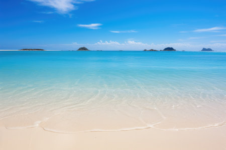 A sandy beach with clear blue water and small islands in the distanceの素材