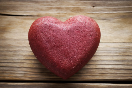A heart shaped cookie sitting on top of a wooden tableの素材
