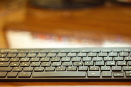 Keyboard on black table background with blurred background.