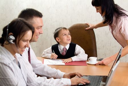 Pretty kid in the office chair with the smiling staffの写真素材