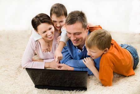 happy family  lying and looking at laptopの写真素材