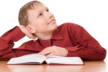 beautiful boy sitting with a book and dreamsの写真素材