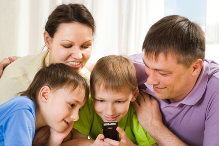 happy parents and their children together lie on the carpetの写真素材