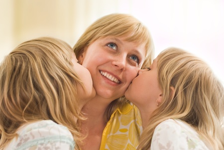 two daughters together kissing his lucky mom