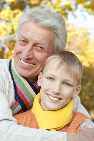 grandfather keeps his grandson in an outdoorの写真素材
