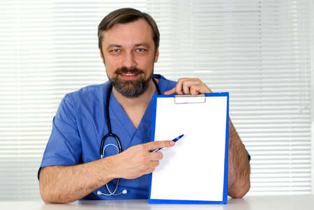 Handsome doctor sitting on the white backgroundの写真素材