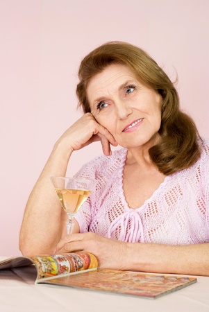 Pretty old woman on a pink backgroundの写真素材