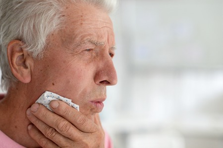 sad beautiful old man is sick in the roomの写真素材