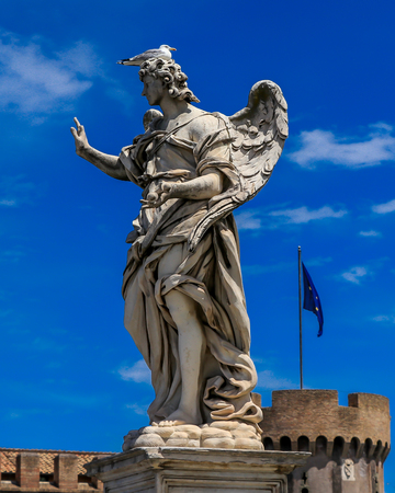 Bird is sitting on the statue of an angel, on the background Castel Sant Angelo and the flag of EUのeditorial素材