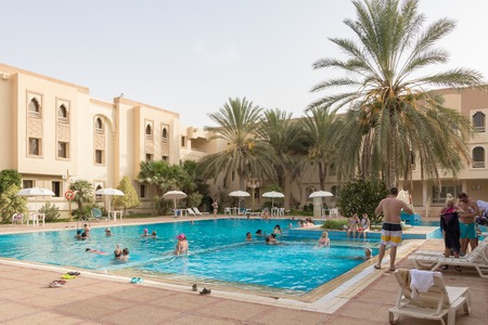 Douz, Tunisia - July 22, 2018: Swimming pool with tourists near Sahara desert, Douz, Tunisia, Africaのeditorial素材