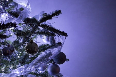 Decorated Christmas tree on blurred purple backgroundの写真素材