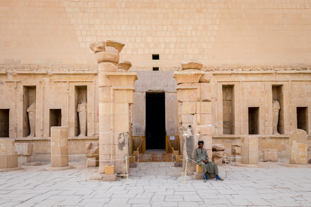 Luxor, Egypt - April 16, 2019: Man in traditional Egyptian dress sits at the entrance to the Hatshepsut templeのeditorial素材