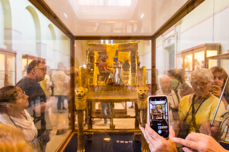 Cairo, Egypt - April 19, 2019: The golden throne of Tutankhamen surrounded by touristsのeditorial素材