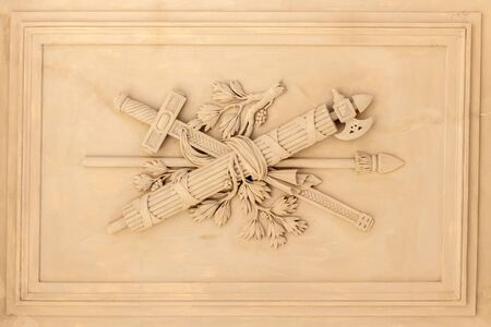 Decorative warrior sword, spear and ax artistic element on the facade of an old building in Vienna,...