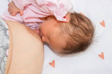 Close up mother breastfeeding an infant. Mother breastfeeding her baby with breast milk. The baby...