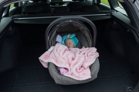 Baby girl sleeping in a safety child car seat.の写真素材