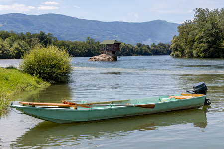 Small fishing boat in front of the famous wooden house on the Drina river in Bajina Basta, Serbia.