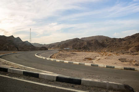 Hot desert road with mountains with dramatic sky in Egypt, Africa