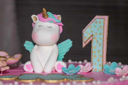 Pink cake. Unicorn cake with pink frosting and number one decoration.の写真素材