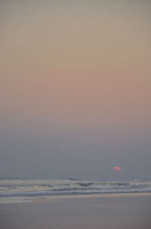 sunet at a seabeach as the sun fades inot the horizonの写真素材
