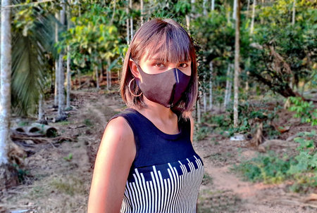 Ranong/ Thailand- 4.1.2020: there is no chance of Corona or Covid-19, for asian tanned beautiful women, is serious, wears a black mask, in a black-white dress, standing among nature in a rural area.のeditorial素材