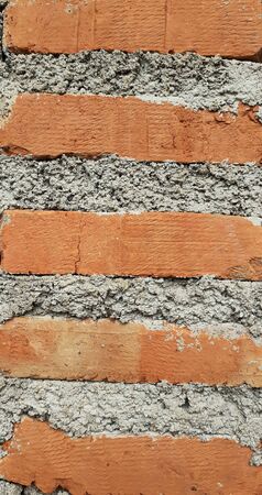 Close-up of a gray and red brick wall, with a half-wall brick wallpaper, cement texture concept...