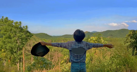 Ranong, Thailand- 4.7.2020: Asian girl holding hat stand back pose a happy landscape in the morning....