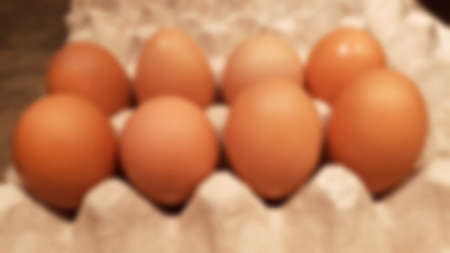 Close-up blurred background of brown box raw chicken eggs, cooking ingredients, with bokeh...