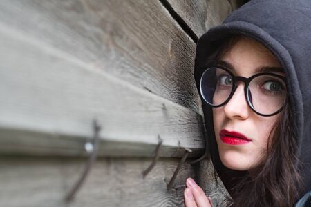 Model at the wooden wall in the hoodの写真素材