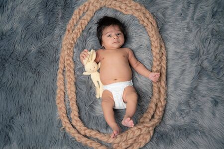 Child baby portrait . Sweet tot little child on a grey fur blanket. Awake Newborn with teddy bearの写真素材