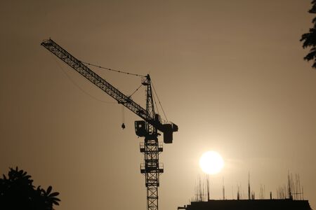 Crane and construction site at sunset stock photoの写真素材