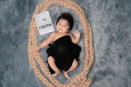 Close up of 1.5 month baby boy with black shawl, different posingの写真素材